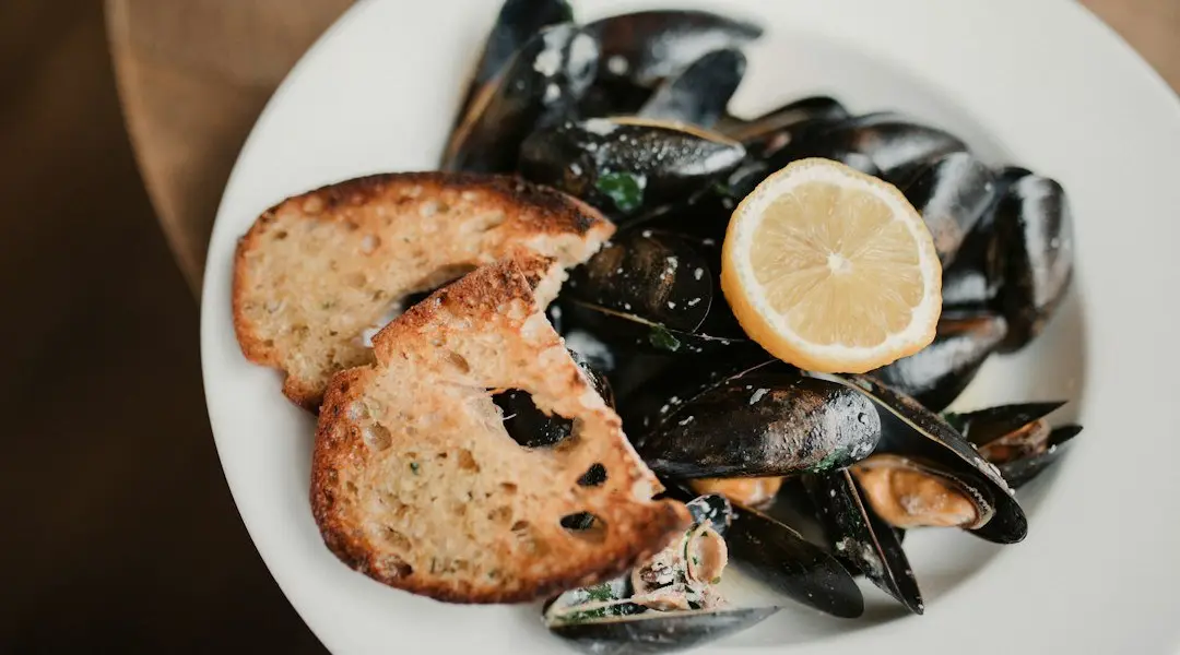 Moules marinières fumantes dans une marmite, coquilles ouvertes, persil haché et échalotes